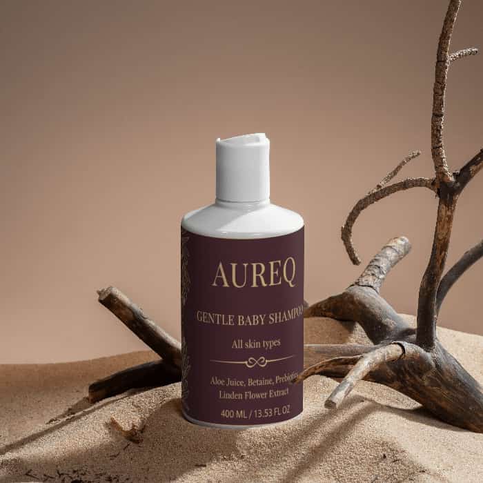 Gentle Baby Shampoo - Nurturing Care for Delicate Scalps bottle on a sandy background.