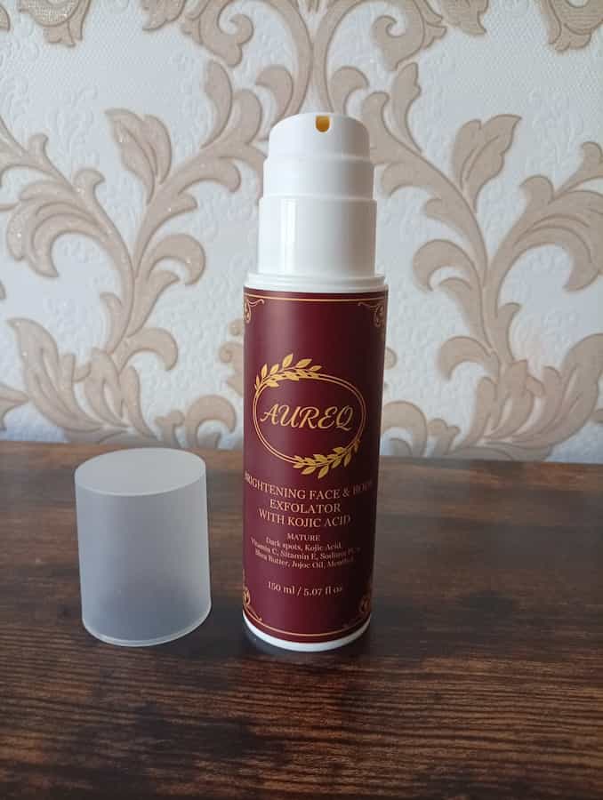 Skincare product bottle with maroon label on a wooden surface