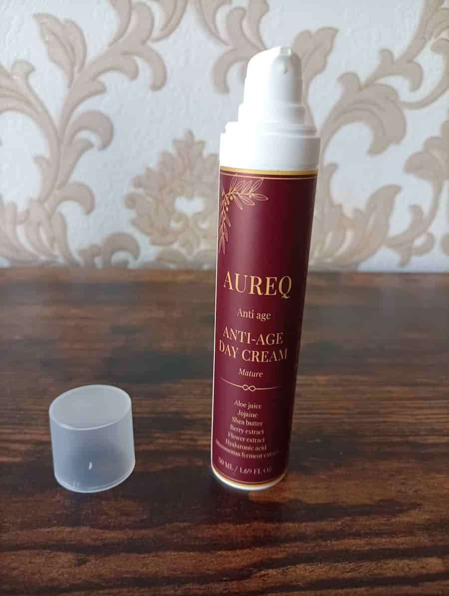 Anti-aging day cream bottle on a wooden surface with decorative background