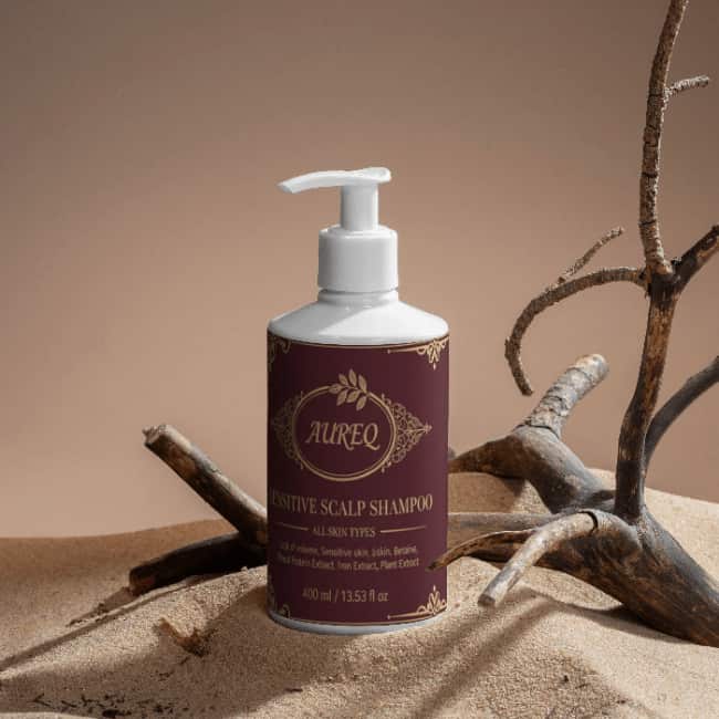 Sensitive Scalp Shampoo in a bottle displayed on sand with twigs, designed for dry and sensitive scalps.