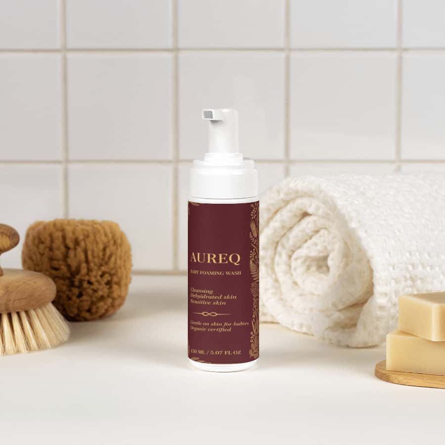 AUREQ Baby Foaming Wash bottle surrounded by soft bath accessories, perfect for gentle cleansing.