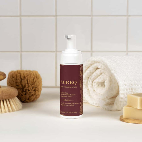 AUREQ Baby Foaming Wash bottle surrounded by soft bath accessories, perfect for gentle cleansing.