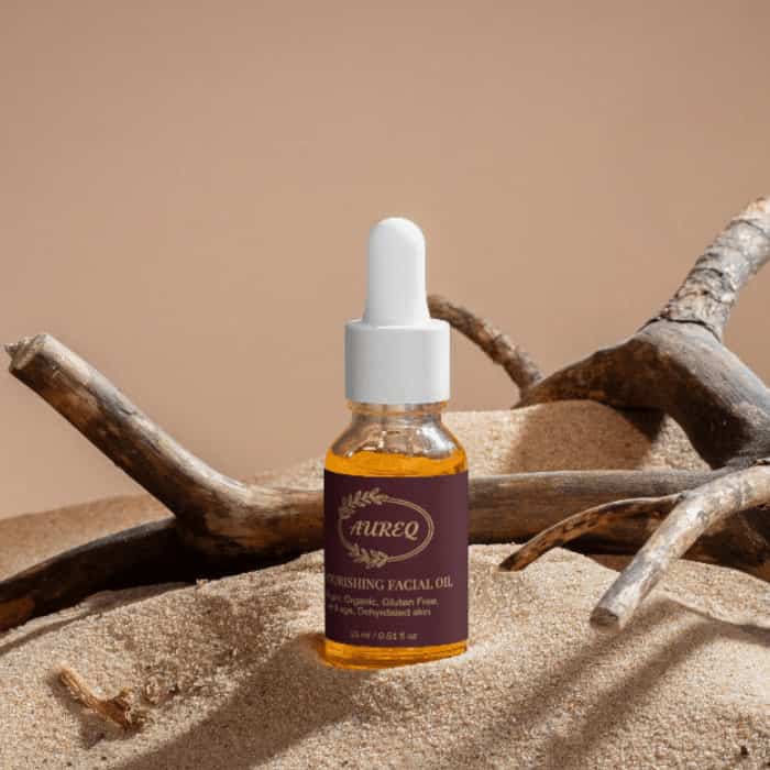 Aireq Nourishing Facial Oil bottle on sand with branches, showcasing organic skincare for deep nourishment.