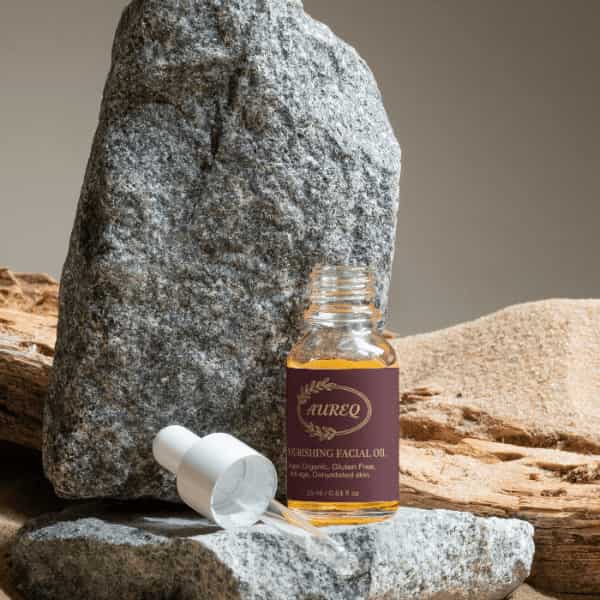 Nourishing Facial Oil bottle placed on stones and wood, showcasing organic skincare essentials for radiant skin.