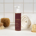 AUREQ Baby Body Lotion - Organic Hydration for Delicate Skin on a bathroom countertop with towels.