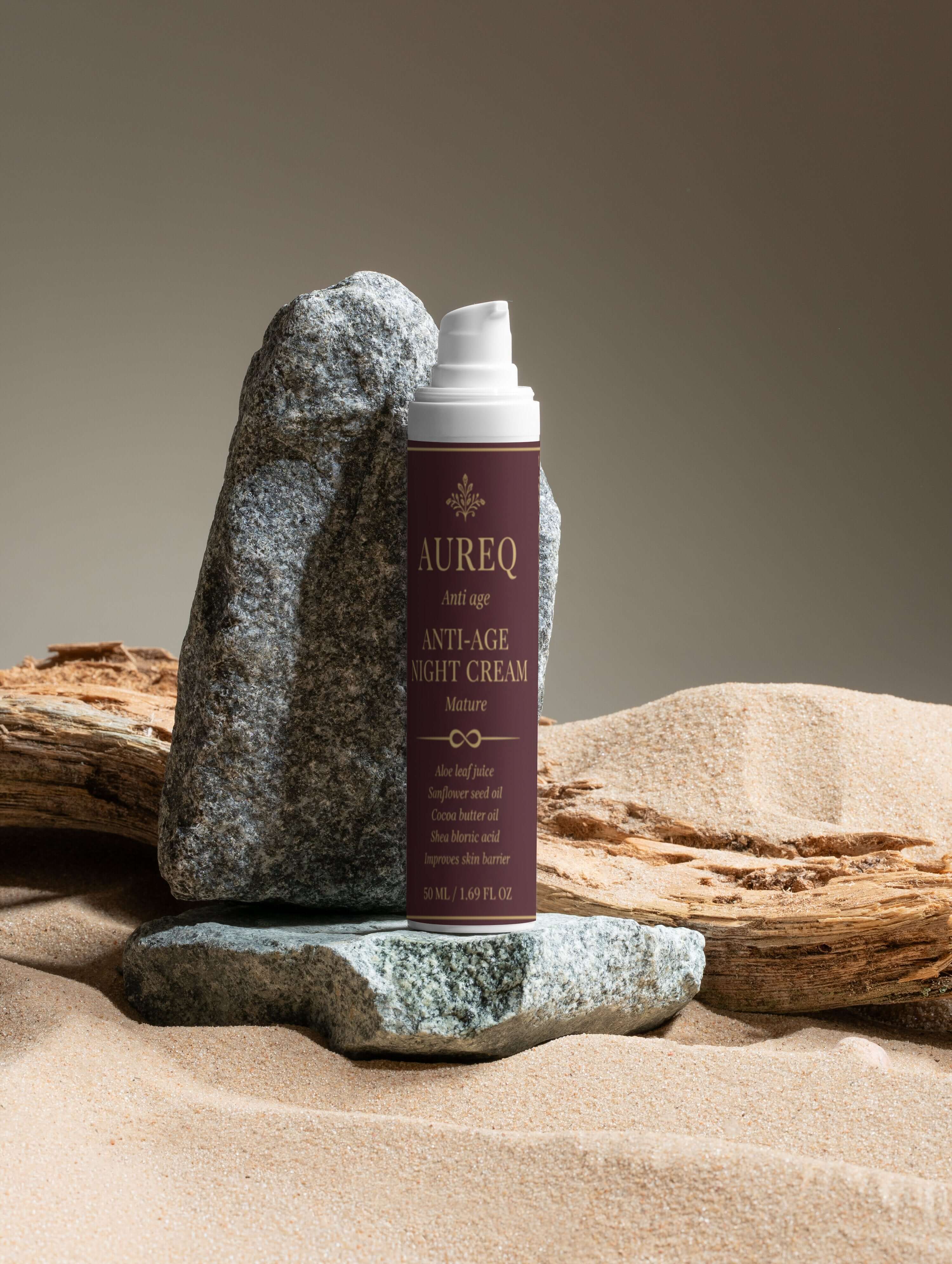 Collagen Anti-Age Night Cream bottle displayed on rocks in sand, emphasizing hydration and anti-aging benefits.